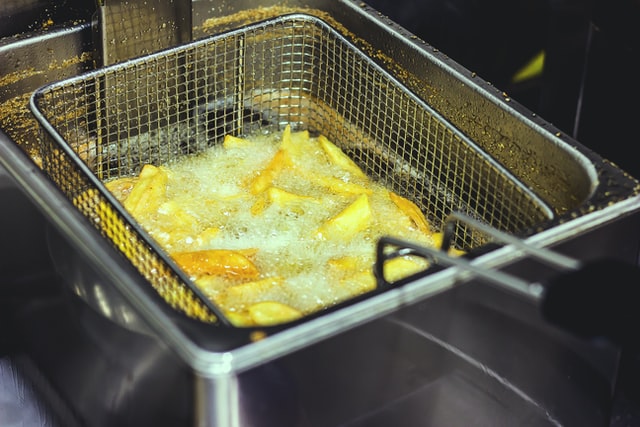 kentang iris sedang digoreng dengan deep fryer